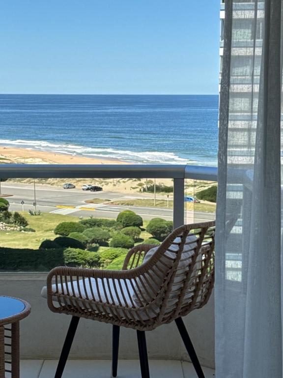 een bankje op een balkon met uitzicht op de oceaan bij Apto Punta del Este stop 4 playa brava in Punta del Este