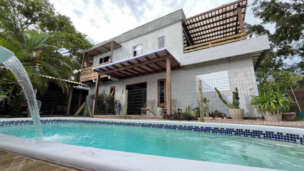 a house with a swimming pool in front of a house at Casa das Palmeiras in Imbituba