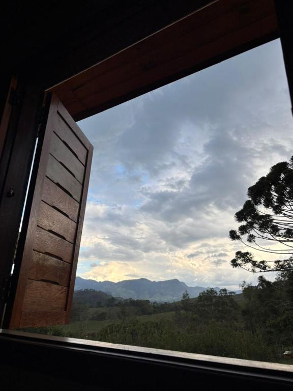 a window with a view of a mountain view at Pousada Morada Canto do Sol in São Bento do Sapucaí