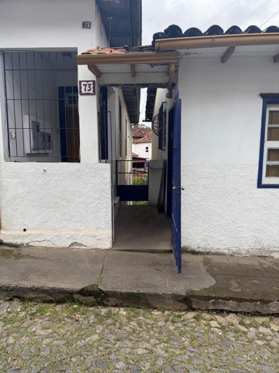 an open door of a white building with a gate at Refúgio Colonial 3 - Antonio Dias in Ouro Preto