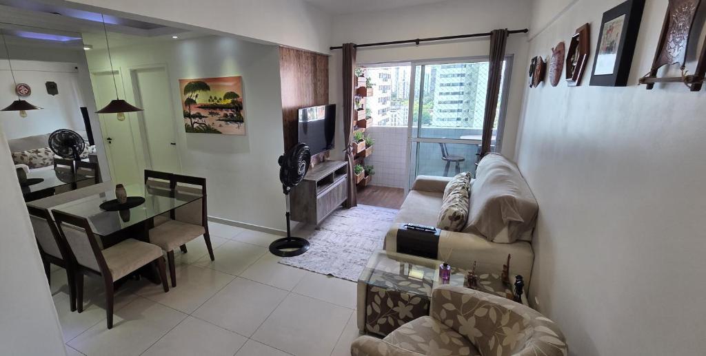 een woonkamer met een bank, een tafel en een televisie bij Morada Pio IX in Recife
