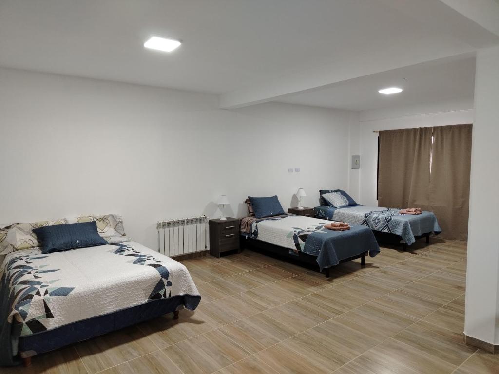 a room with three beds in a room at Alvarez Apart in Ushuaia