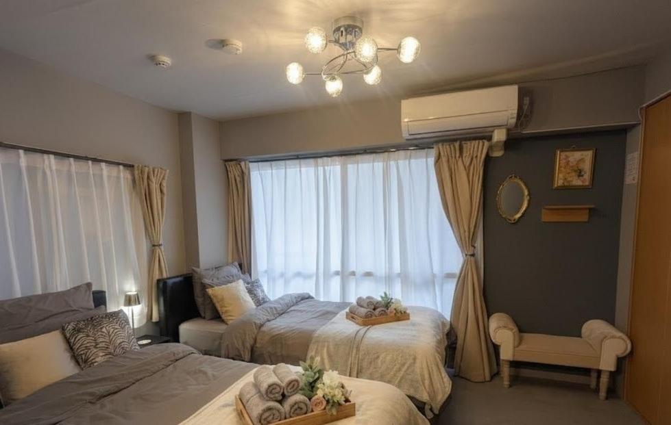 a bedroom with two beds and a window at Sakura Fan 2F in Tokyo
