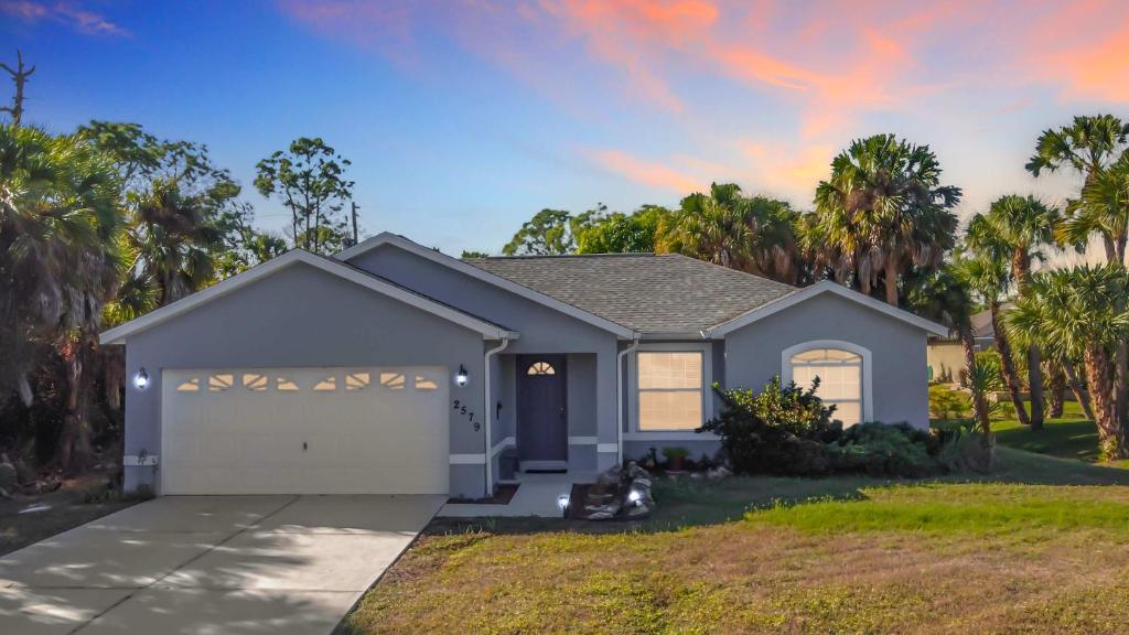 ein Haus mit einer Garage mit Palmen in der Unterkunft Gulf Coast Home 3BR2BA for 8 in North Port