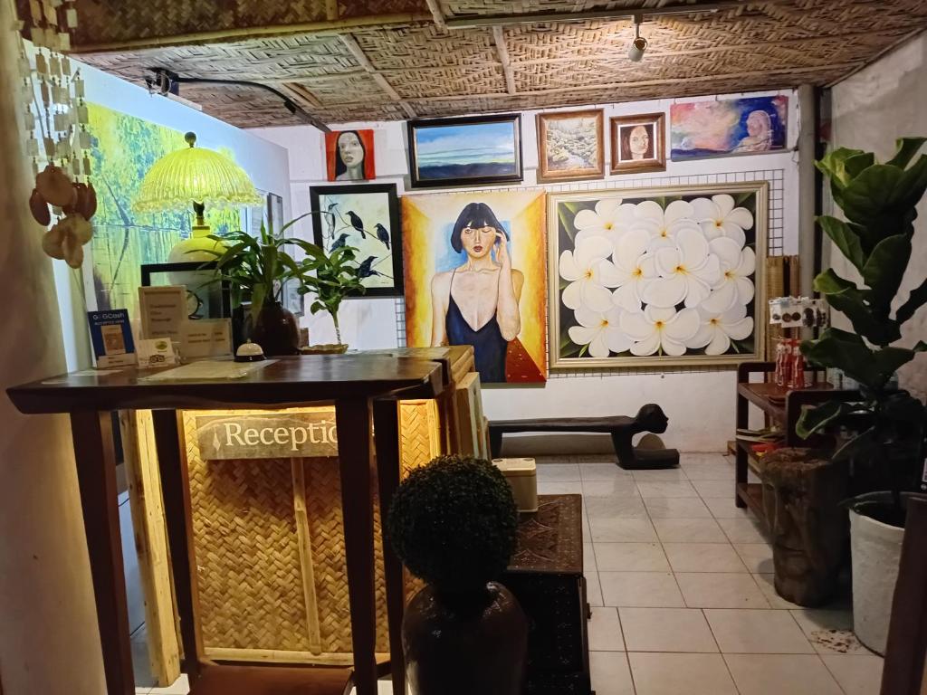 a room with paintings on the wall and a table at La Vida Hostel Samal Island in Samal