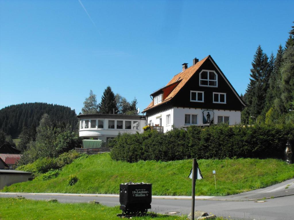 ein Haus auf einem Hügel neben einer Straße in der Unterkunft Ferienwohnung Sonnenhügel in Wildemann