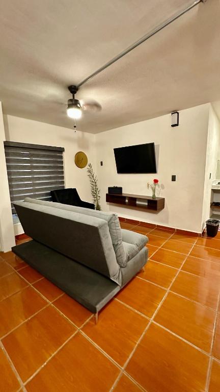 een woonkamer met een bank en een flatscreen-tv bij Hogar Kada in Tepic