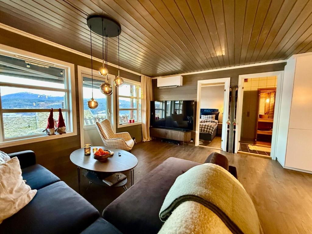 a living room with a couch and a table at Unique view! Modern apartment with sauna in Vossevangen