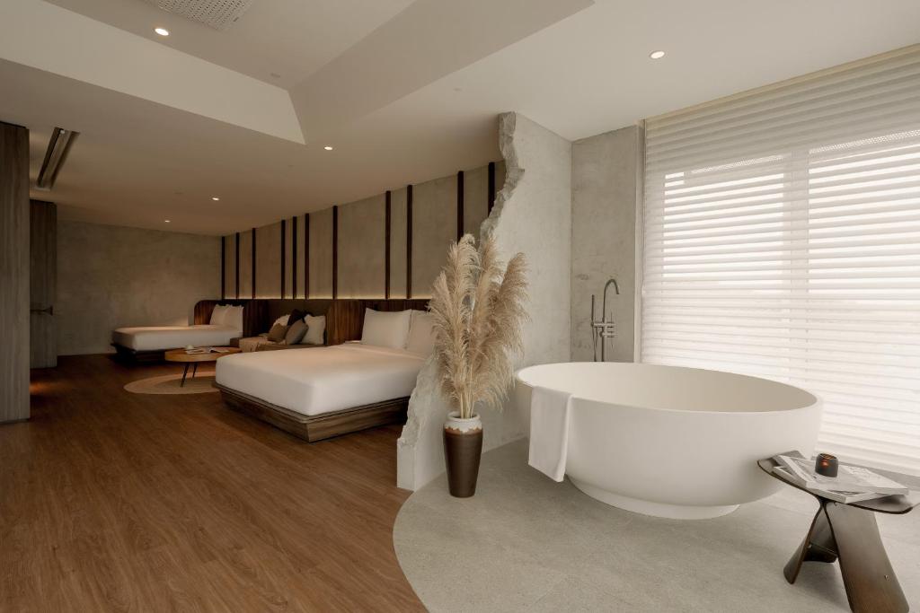 un bagno con vasca e una camera da letto con un letto di The Cara Hotel a Kota Kinabalu