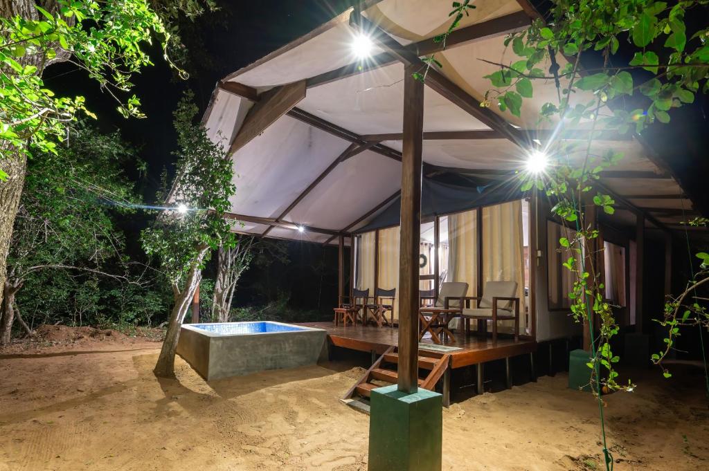 een tent met een jacuzzi in een tuin 's nachts bij Wild Trails Yala by Suri in Yala