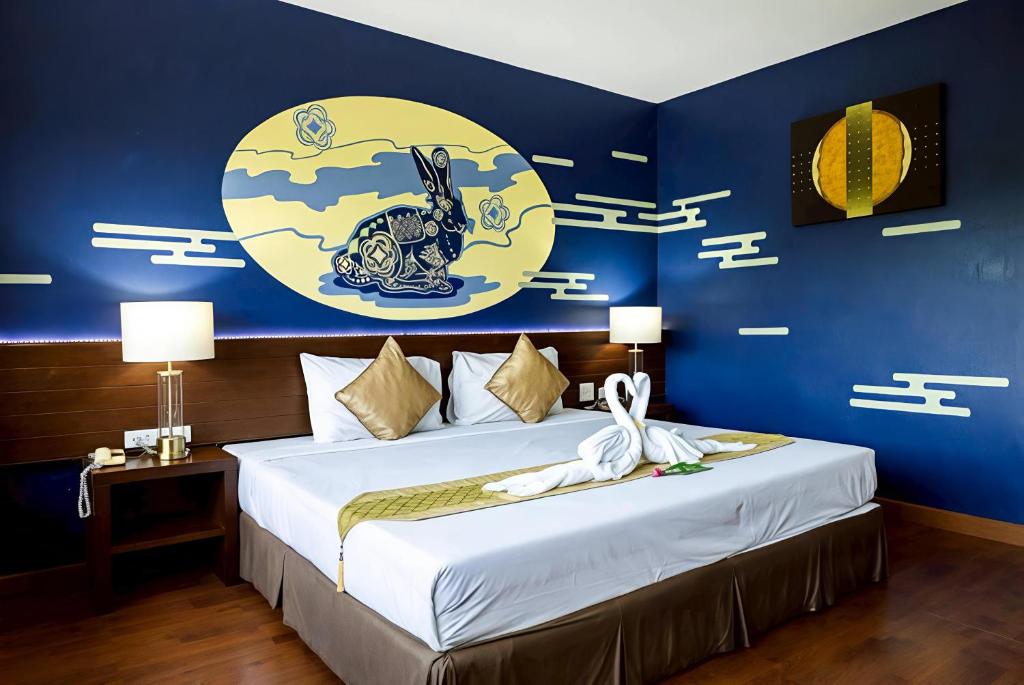 una camera da letto con un letto con una parete blu di The Ligor City Hotel a Nakhon Si Thammarat