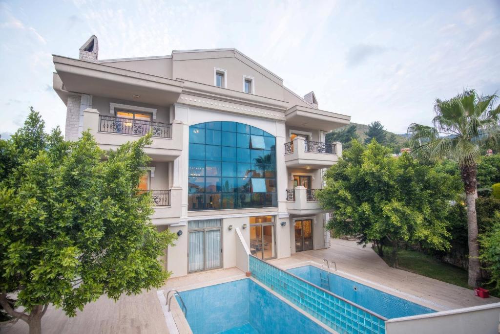 une grande maison avec une piscine devant dans l'établissement Mete 2 Villa İcmeler Marmaris, à İçmeler