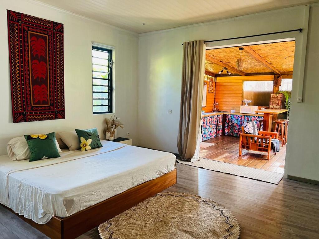een slaapkamer met een bed en een woonkamer bij Fare Miriau in Papara