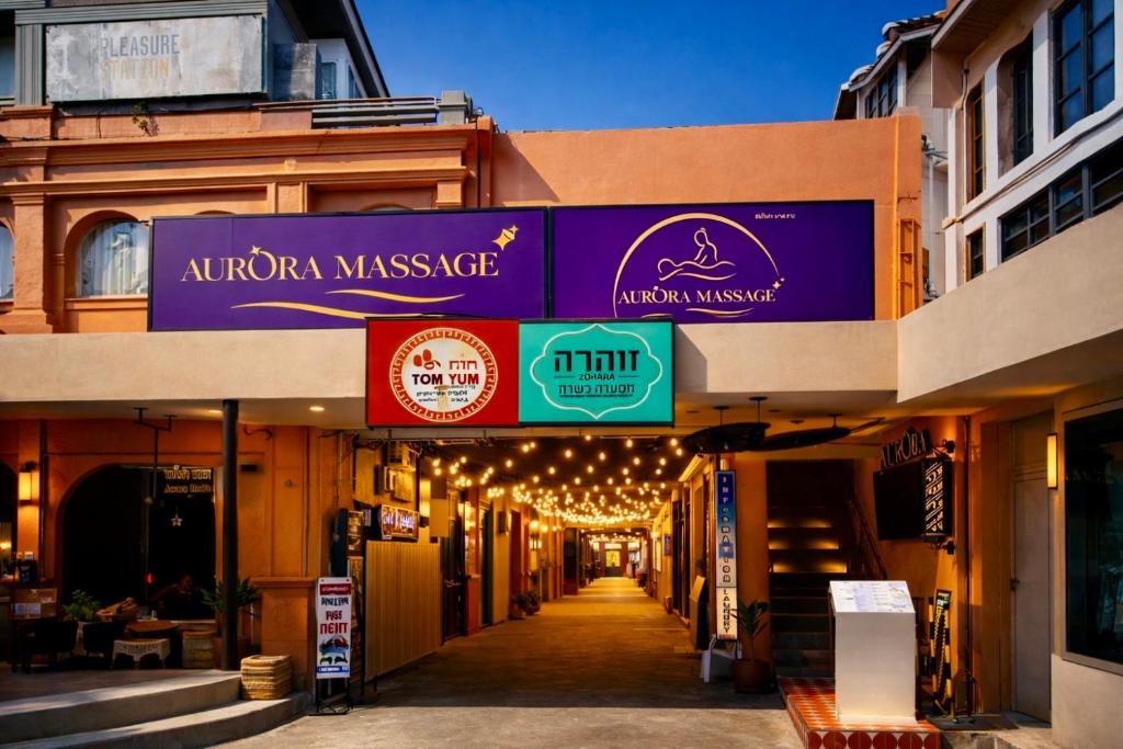 un vicolo con un cartello per un massaggio indo-malacca di Shalom Center chaweng Samui a Chaweng Beach