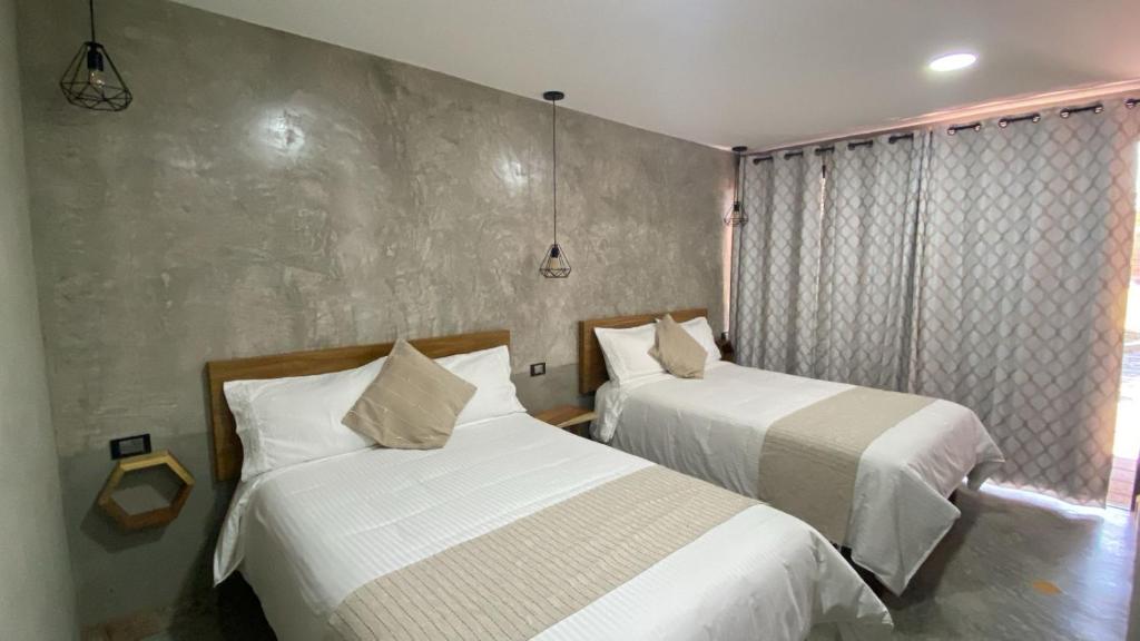 een slaapkamer met twee bedden en een raam bij Hotel Casa Grangelo in Atlixco