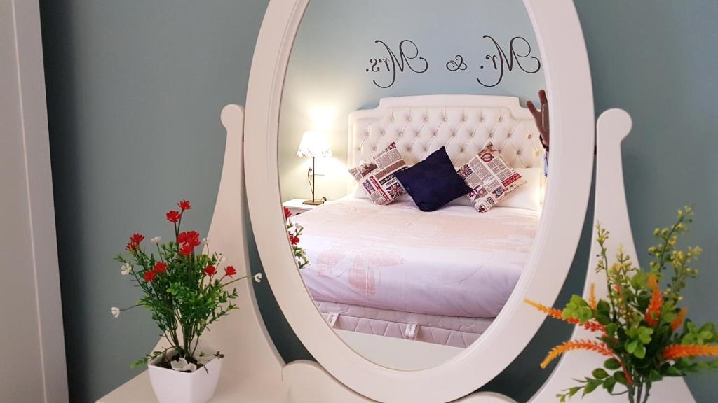 sypialnia z białym łóżkiem w lustrze w obiekcie Gran Apartamento Centro Histórico w Maladze