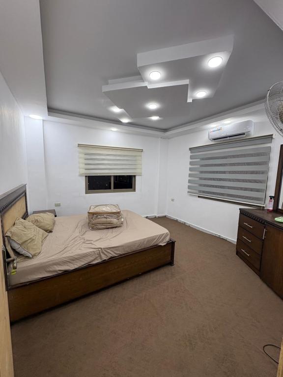 a bedroom with a bed and a dresser and a window at Golden Stay in Jerash