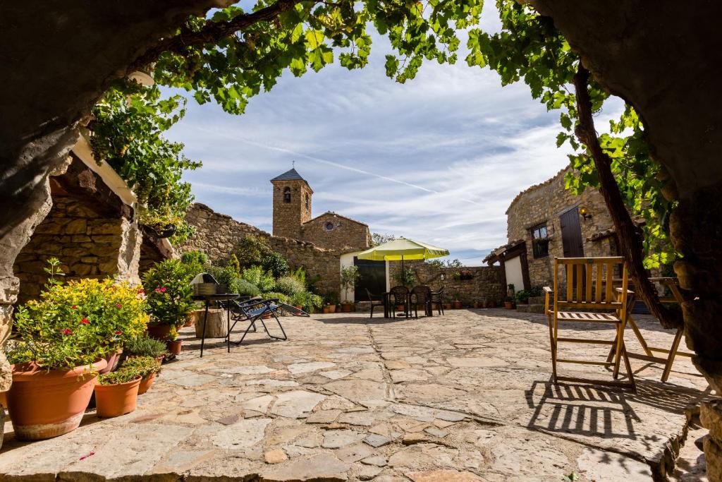 a stone courtyard with chairs and a church at Casa Mauri in Tremp