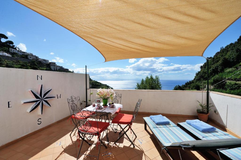 um pátio com uma mesa e cadeiras numa varanda em Tenuta Mamma Carmela em Amalfi