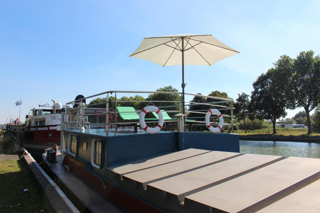 um barco com guarda-sol e cadeiras em Spits-Lucie B&B em Izegem