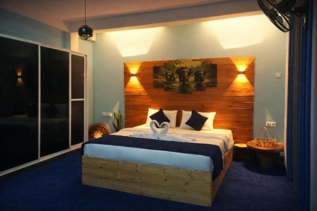 een slaapkamer met een groot bed met een houten hoofdeinde bij Off grid Ella Homestay in Ella