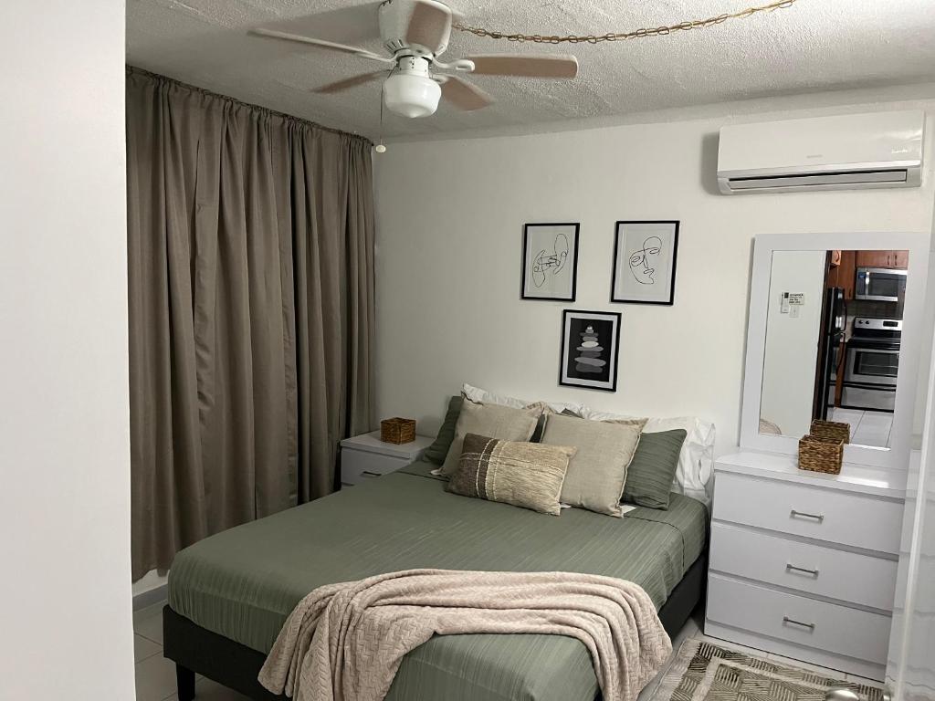 ein Schlafzimmer mit Bett und Deckenventilator in der Unterkunft Casa Peace Haven Beach House Aguada in Aguada