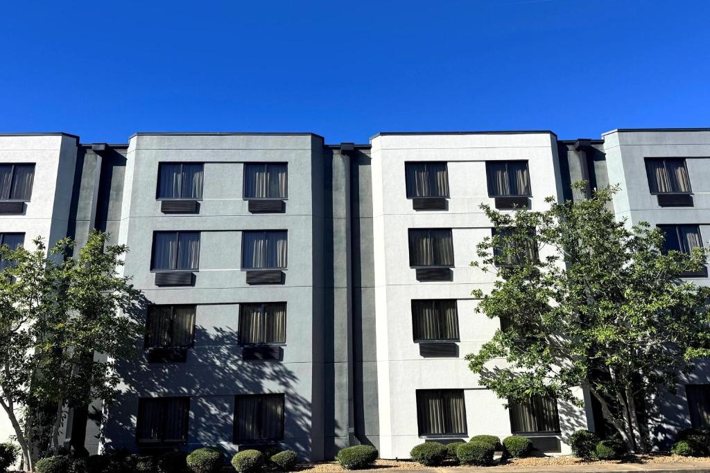 弗洛伍德Travelodge by Wyndham的一栋白色建筑，前面有树