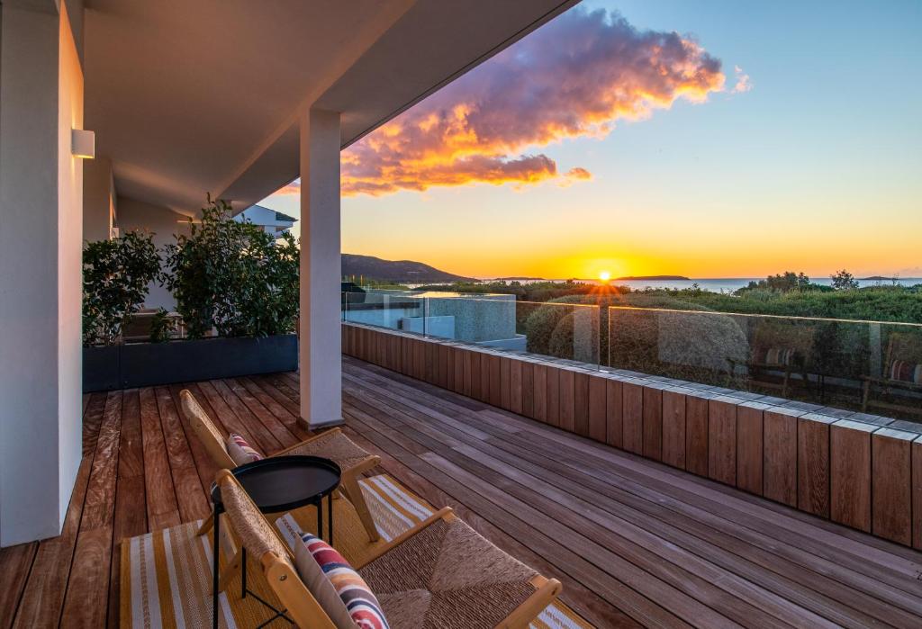 a balcony with a view of the sunset at Villa AzaiTu Suites in Porto-Vecchio