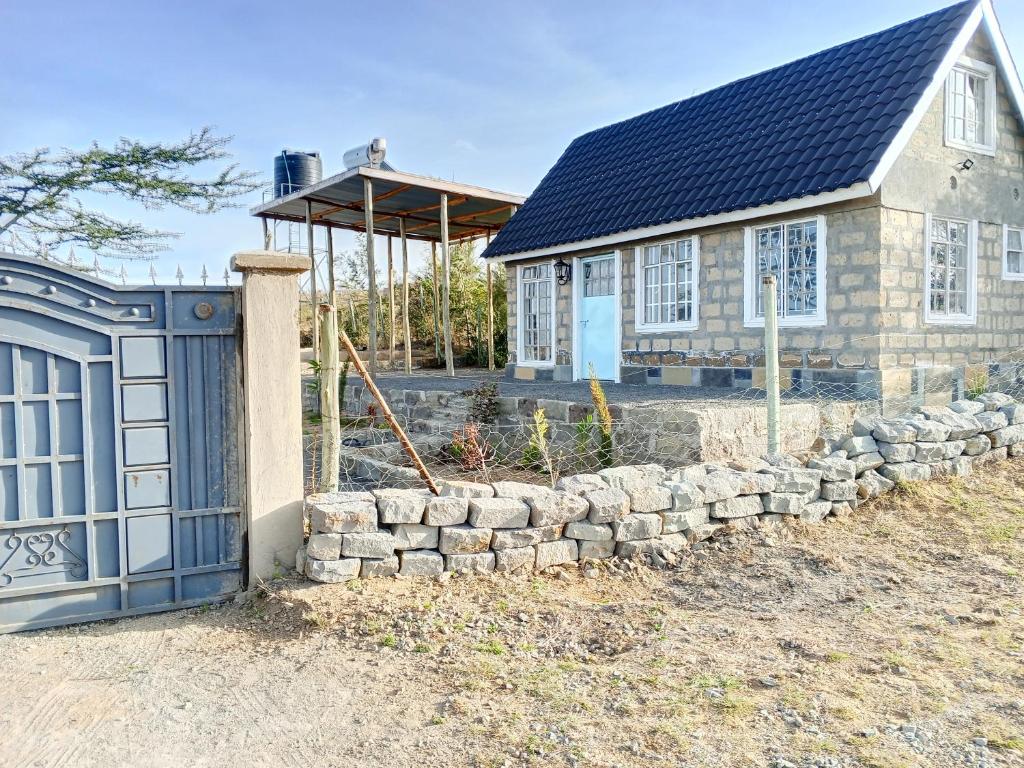 a house with a stone retaining wall and a garage at Longonot Cabin in Longonot