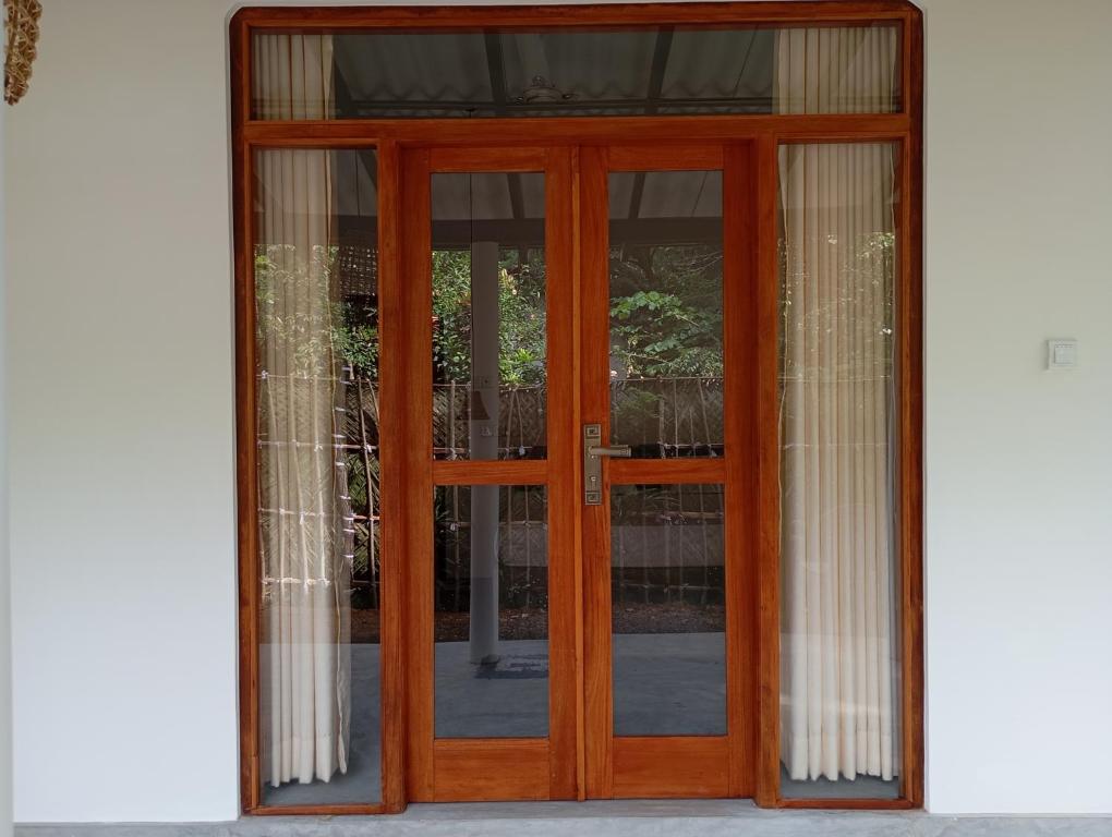 a wooden door with glass windows on a building at Emerald retreat in Ahangama