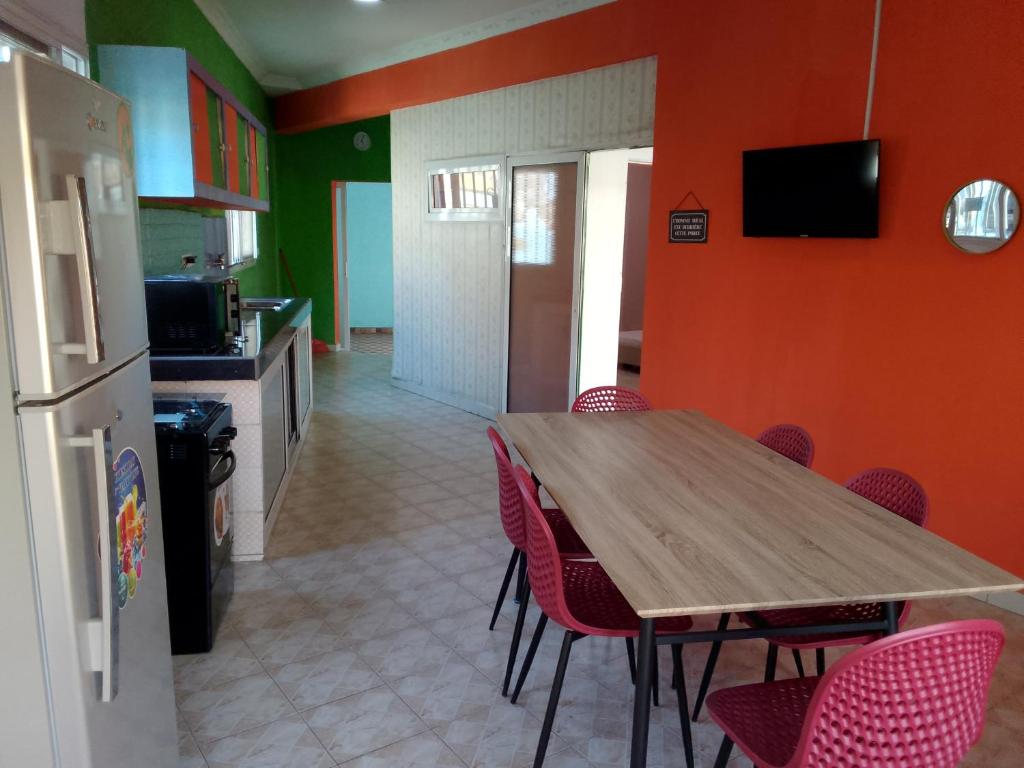 een keuken met een houten tafel en rode stoelen bij Sakinu Appartement in Mahajanga