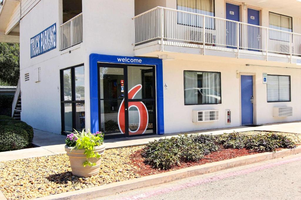 una señal de bienvenida frente a un edificio en Motel 6-Abilene, TX, en Abilene