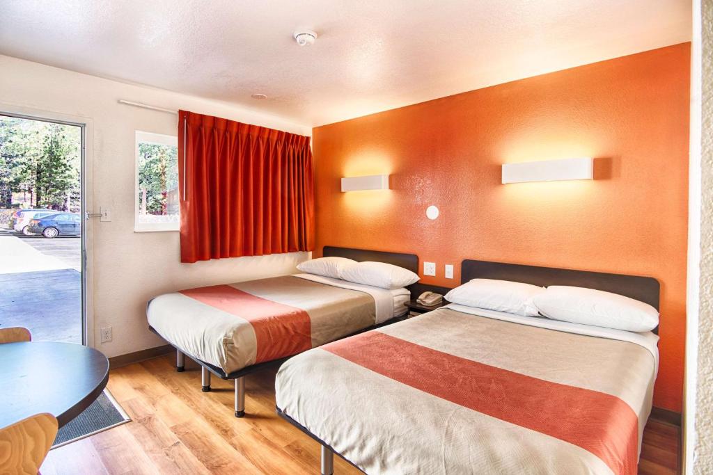 a hotel room with two beds and a table at Motel 6-Mammoth Lakes, CA in Mammoth Lakes