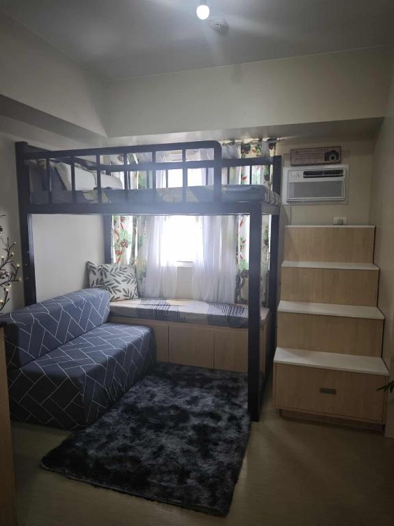 a bedroom with a bunk bed and a couch at The Comfort Pad in Cagayan de Oro