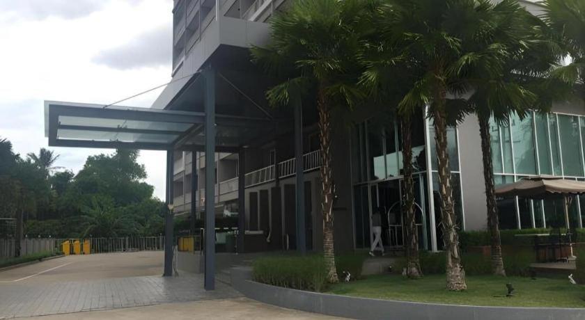 een gebouw met palmbomen ervoor bij Chaisaeng Villa in Sing Buri