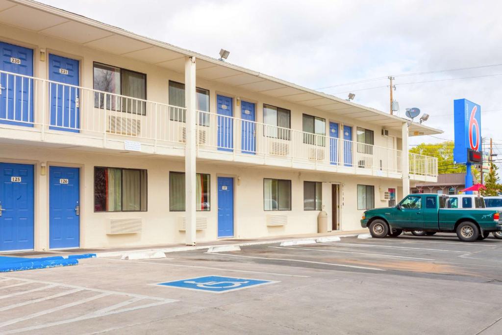 un hotel con un camión verde estacionado frente a él en Motel 6-Klamath Falls, OR en Klamath Falls