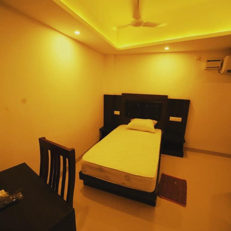 a bedroom with a bed and a table and a table and a table at Vinayaka Regency in Trivandrum