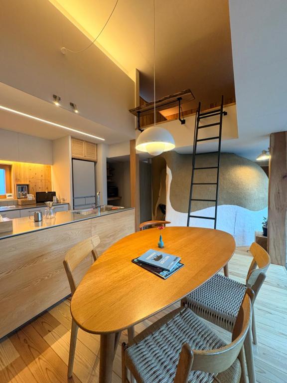 een keuken en eetkamer met een houten tafel en stoelen bij Peanuts Nest in Nagano