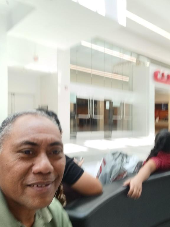 American Samoa的一名男子坐在火车上，面带微笑。