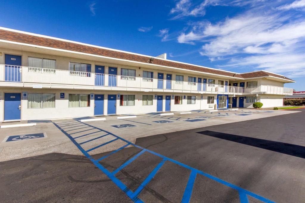 um grande edifício branco com portas azuis e um parque de estacionamento em Motel 6-Phoenix, AZ - North Bell Road em Phoenix