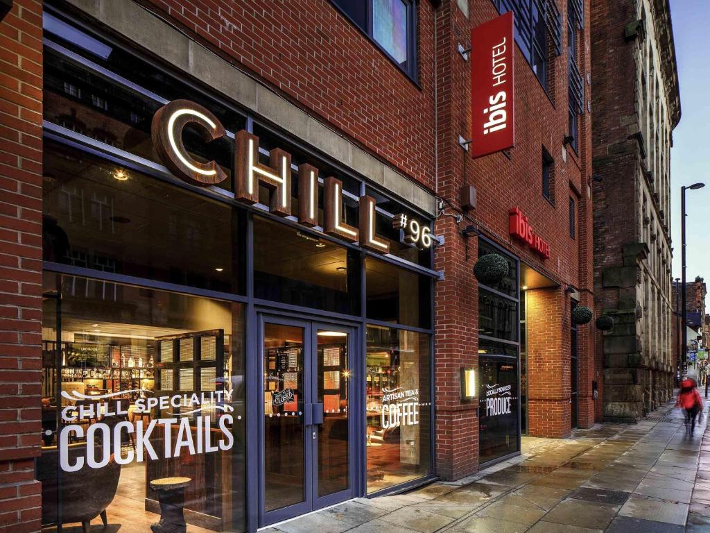 een winkel voor een bakstenen gebouw in een straat bij ibis Manchester Centre 96 Portland Street in Manchester