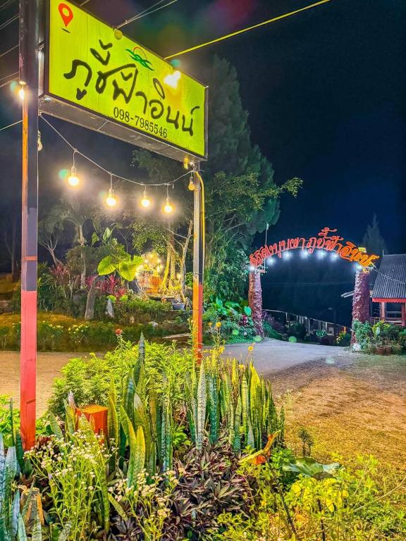 a sign in front of a garden at night at ภูชี้ฟ้าอินน์ รีสอร์ท Phucheefainn Resort in Ban Seng Choi