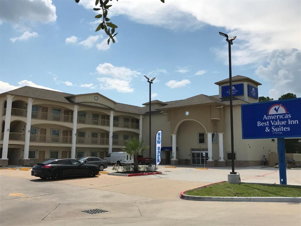 un gran edificio con coches estacionados en un estacionamiento en Americas Best Value Inn & Suites Spring / N. Houston, en Spring