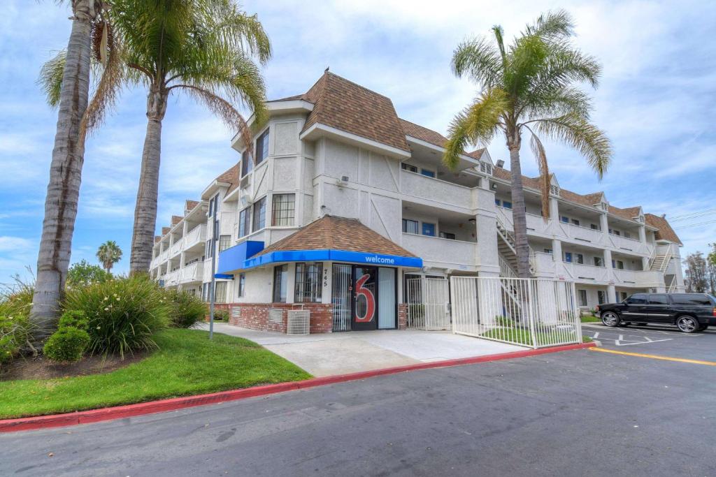 un gran edificio blanco con palmeras delante en Motel 6-Chula Vista, CA - San Diego, en Chula Vista