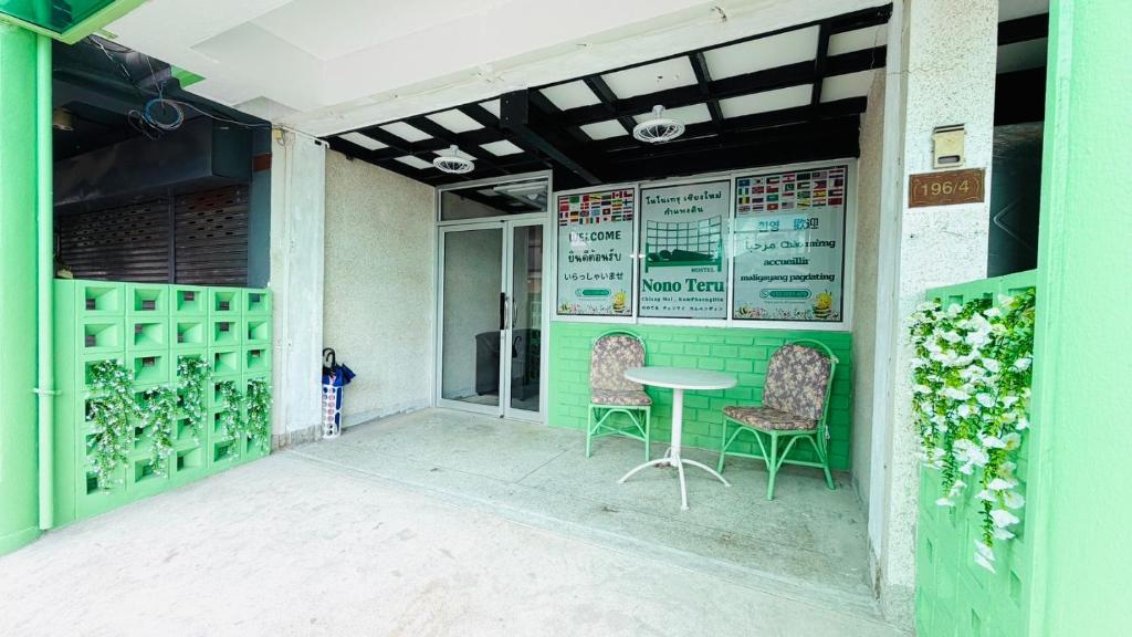un bâtiment écologique avec deux chaises et une table dans l'établissement Nonoteru Chiang Mai , KamPhaengDin, à Chiang Mai