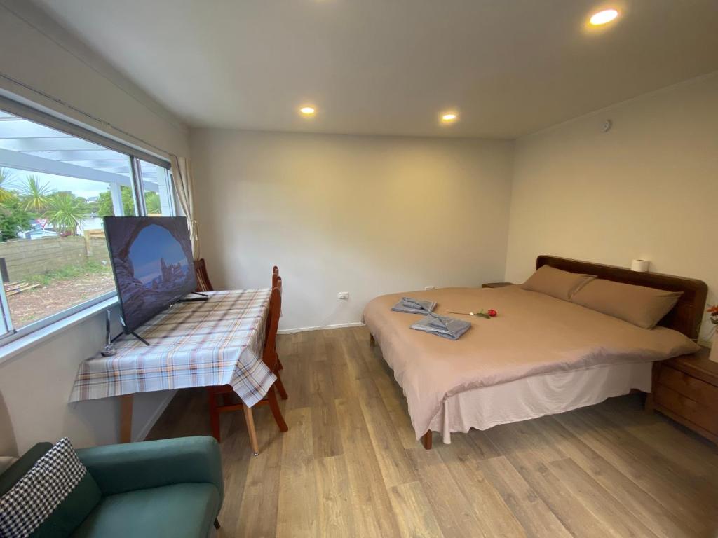 een slaapkamer met een bed, een raam en een bank bij Albany house in Motungarara