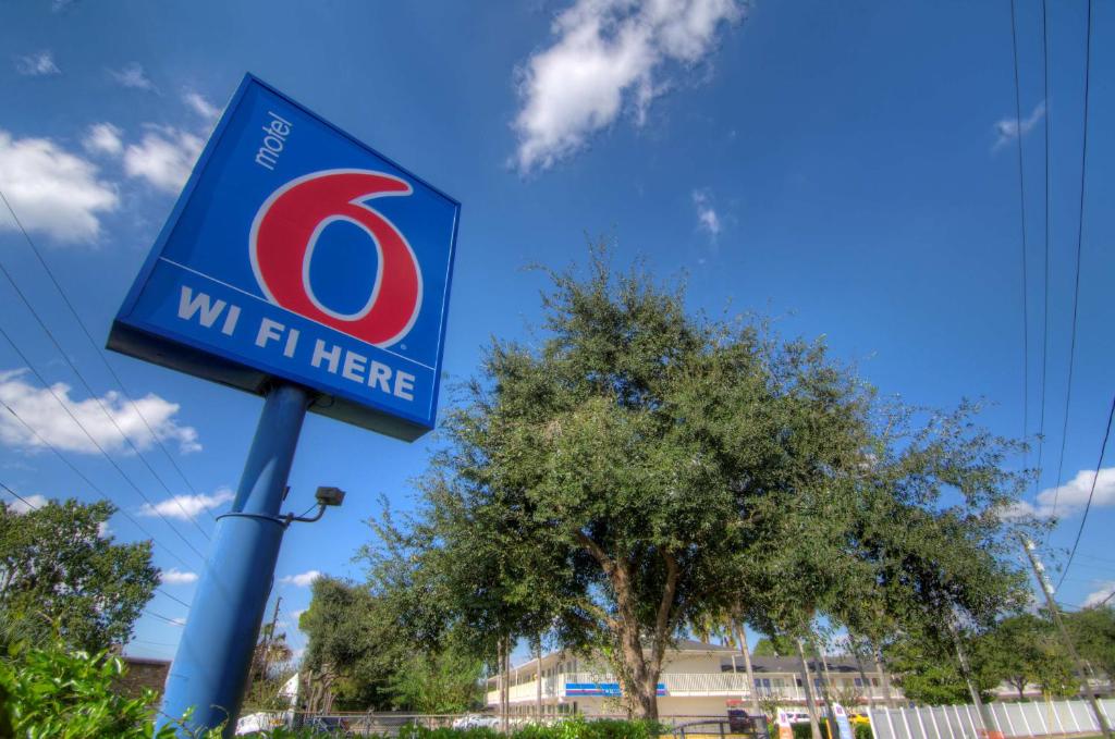 un signo de un ajuste aquí en un poste en Motel 6-Orlando, FL - Winter Park, en Orlando