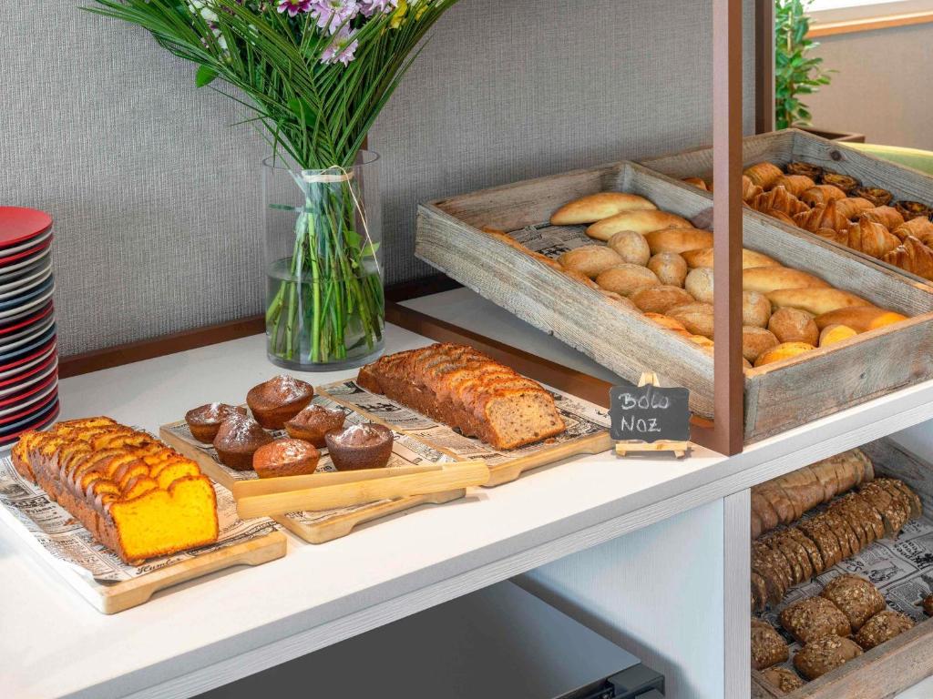 een plank met diverse soorten gebak en brood op een tafel bij Hotel Mercure Porto Gaia in Vila Nova de Gaia