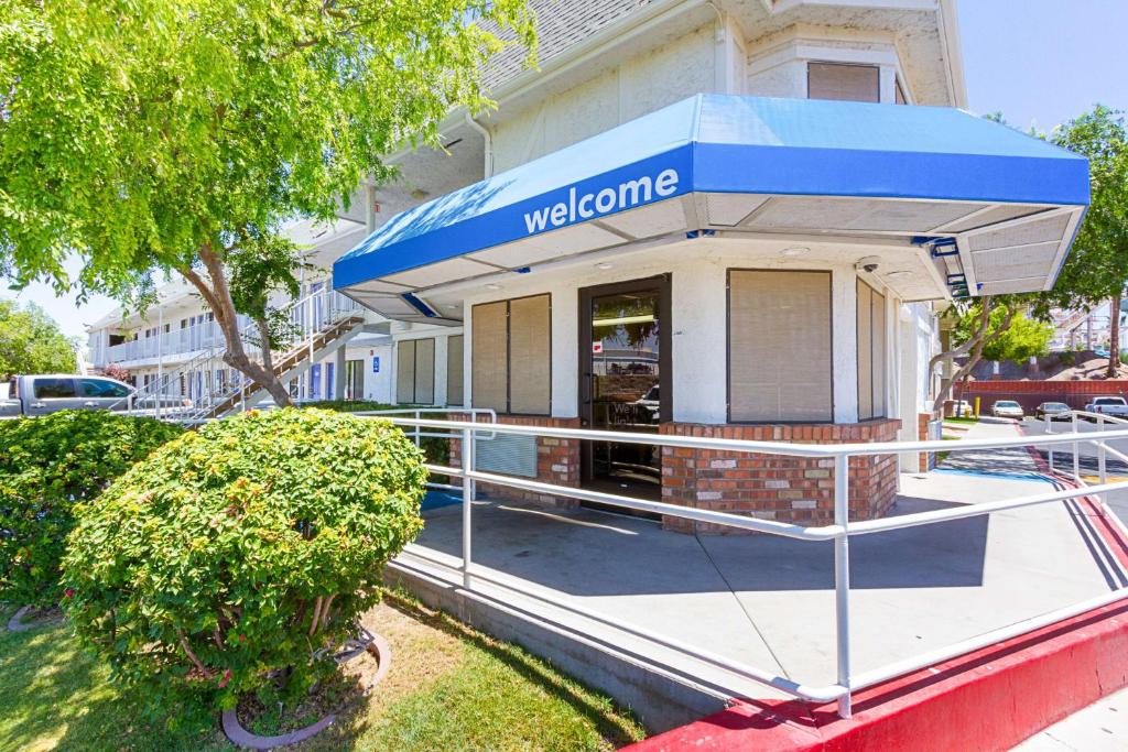 un edificio con toldo azul frente a una tienda en Motel 6-Mesa, AZ - South, en Mesa