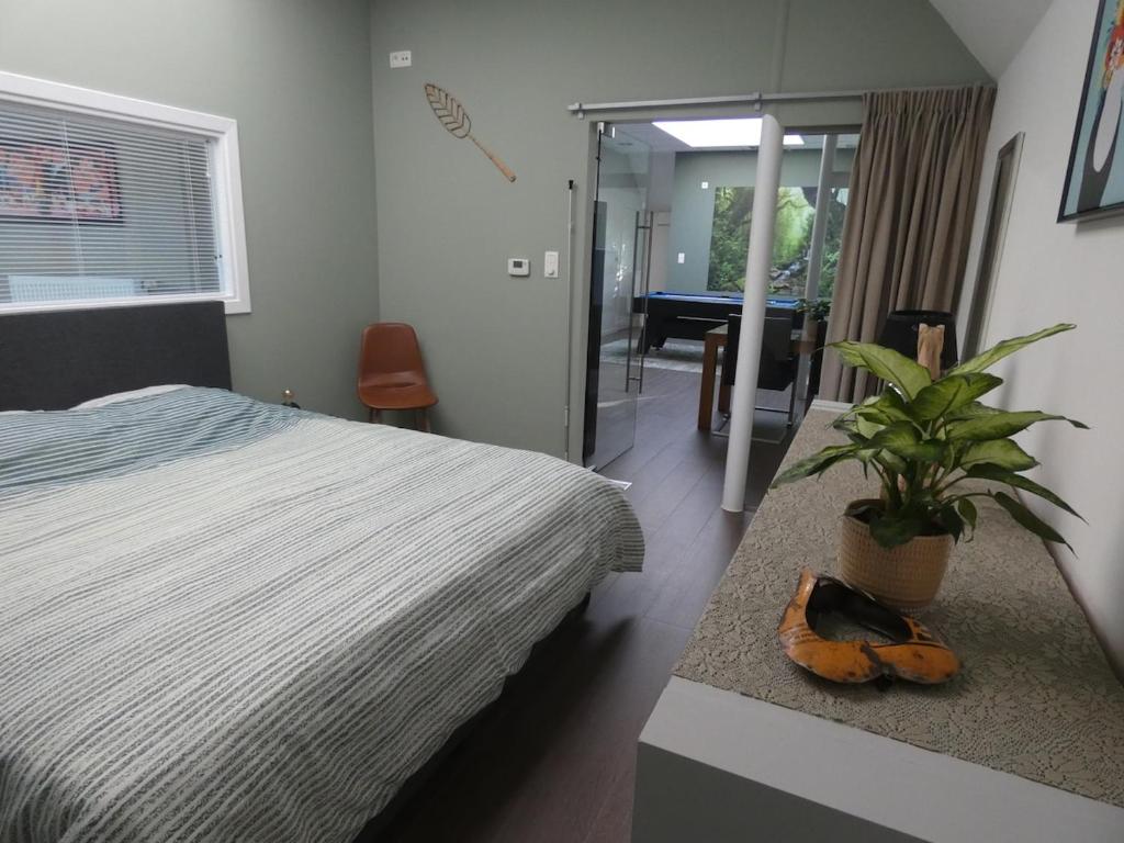 a bedroom with a bed and a potted plant at Gastenverblijf Op den dreef in Hamont